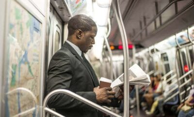 Homem lendo jornal no metro - horas in-tinere